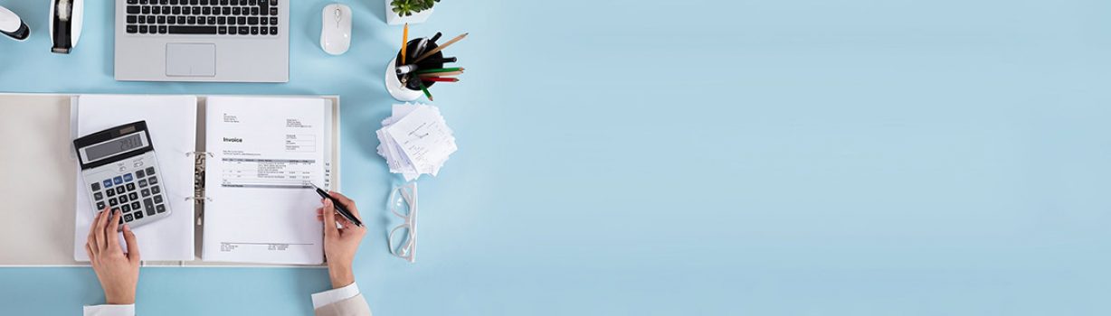 Elevated View Of A Accountant Calculating Invoices Using Calculator On Desk